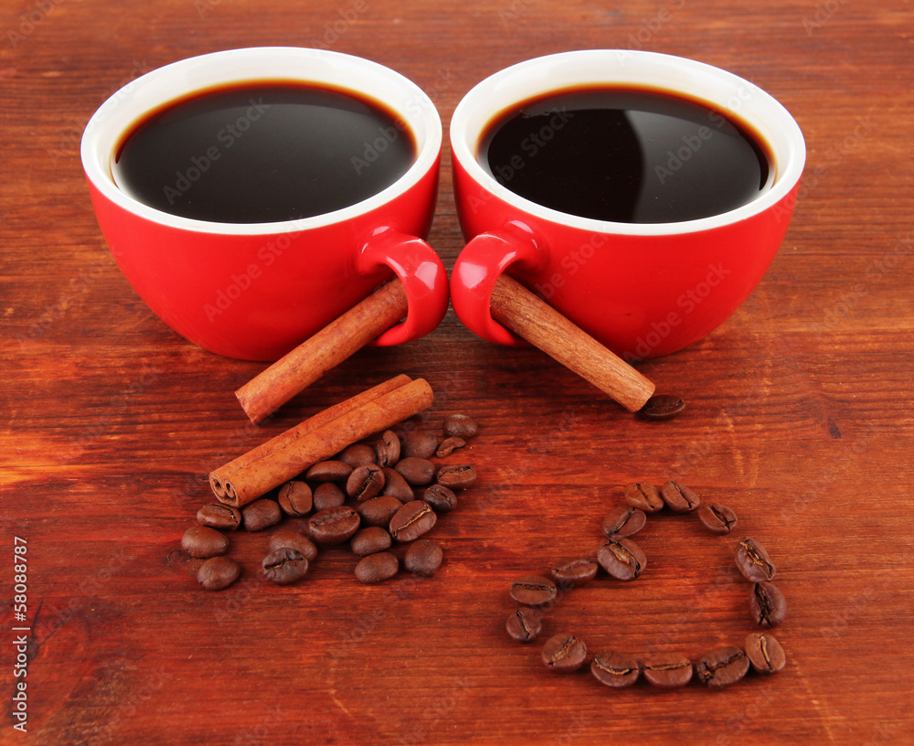 Red cups of strong coffee and coffee beans on wooden background Red cups of strong coffee and coffee beans on wooden background