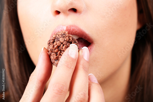 Closeup of woman eating chocolate candy