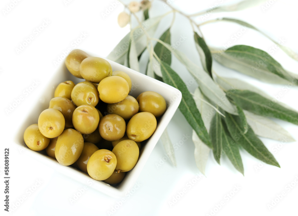 Olives in bowl with branch isolated on white
