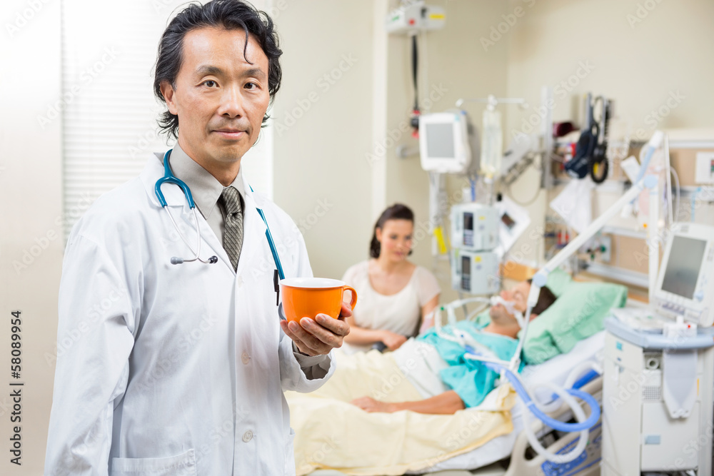 Obraz premium Doctor Holding Coffee Cup With Patient Resting In Hospital