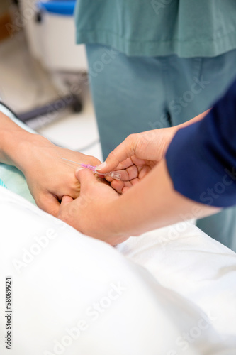 Nurse Injecting Needle In Male Patient s Hand