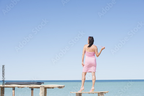 Sexy mature woman posing at tropical beach