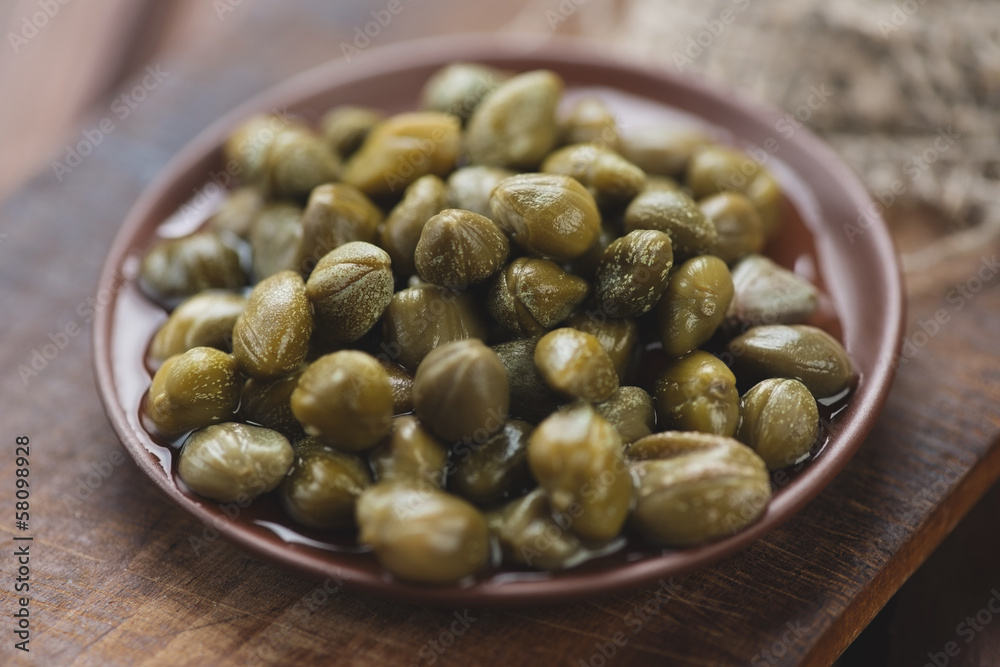 Ceramic plate with marinated capers, close-up Ceramic plate with marinated capers, close-up