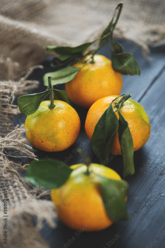 Vertical shot of ripe mandarins with green leaves