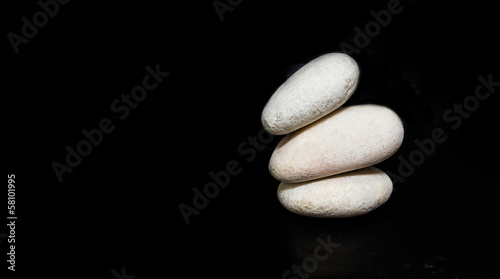 Photography White zen stone over black background