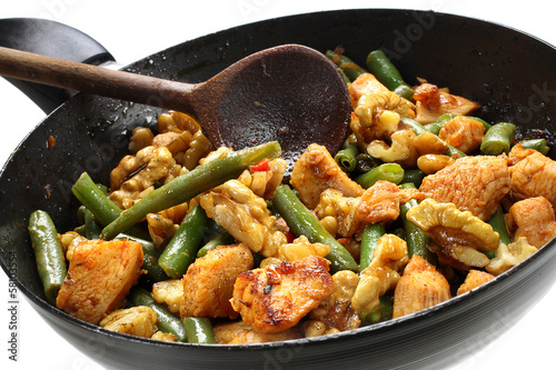 Green beans with chicken and walnuts in a frying pan