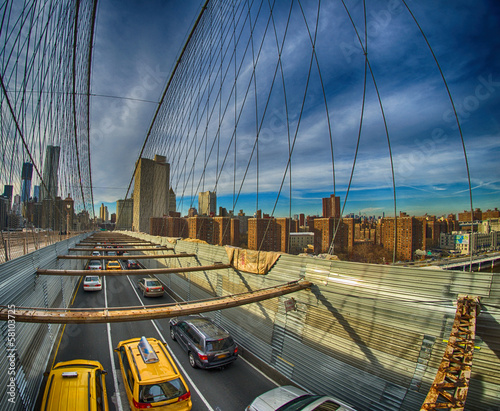 Taxi cab crossing the Brooklyn Bridge in New York, City skyline © jovannig