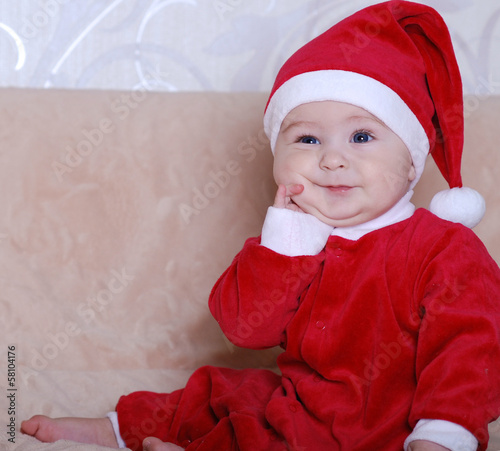 beautiful baby in the hat of Santa Claus with gifts photo