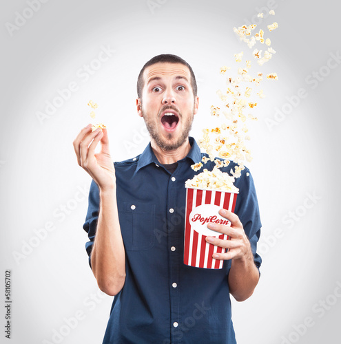 Young men watching a movie with popcorn