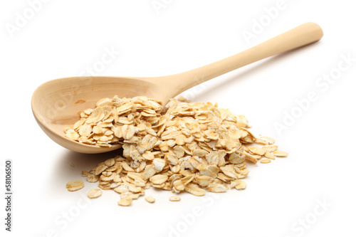 Heap of rolled oats with wooden spoon photo