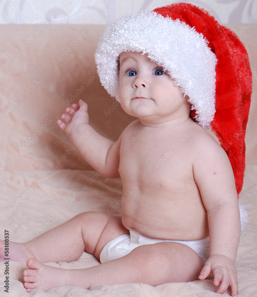 beautiful baby in the hat of Santa Claus with gifts beautiful baby in the hat of Santa Claus with gifts