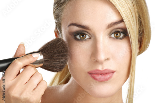 beautiful model applying professional make up using a brush