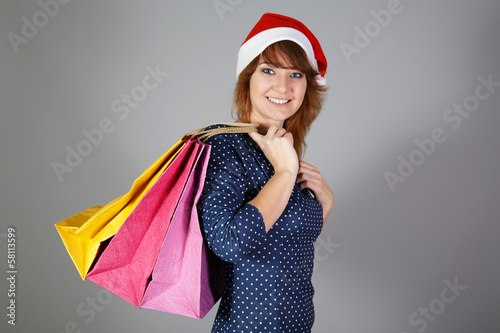 Girl at funny hat and with three paper bags