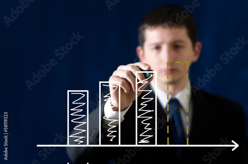 Young businessman drawing graph