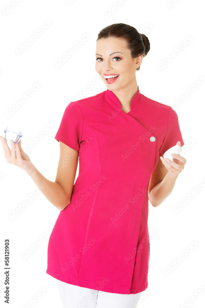 Beautiful attractive beautician holding a cream. Beautiful attractive beautician holding a cream.