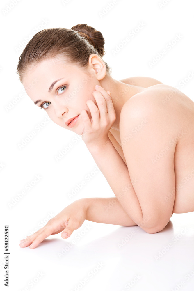 Attractive naked woman proping her head while lying on the floor
