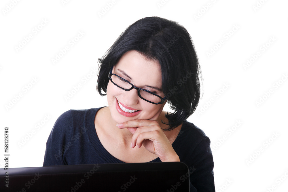 Attractive young woman sitting in front of a laptop. Attractive young woman sitting in front of a laptop.