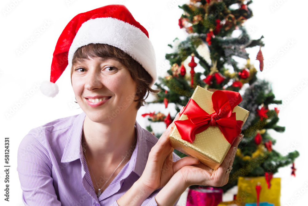 Woman in Santa hat with present under Cristmas tree Woman in Santa hat with present under Cristmas tree
