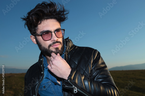 pensive young fashion man with beard and glassess