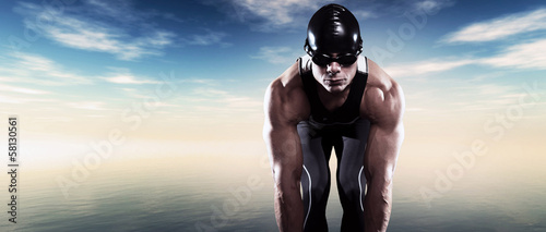 Swimmer triathlon muscled man with cap and glasses outdoor at a