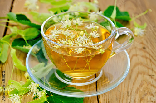 Herbal tea from linden flowers in a cup on the board
