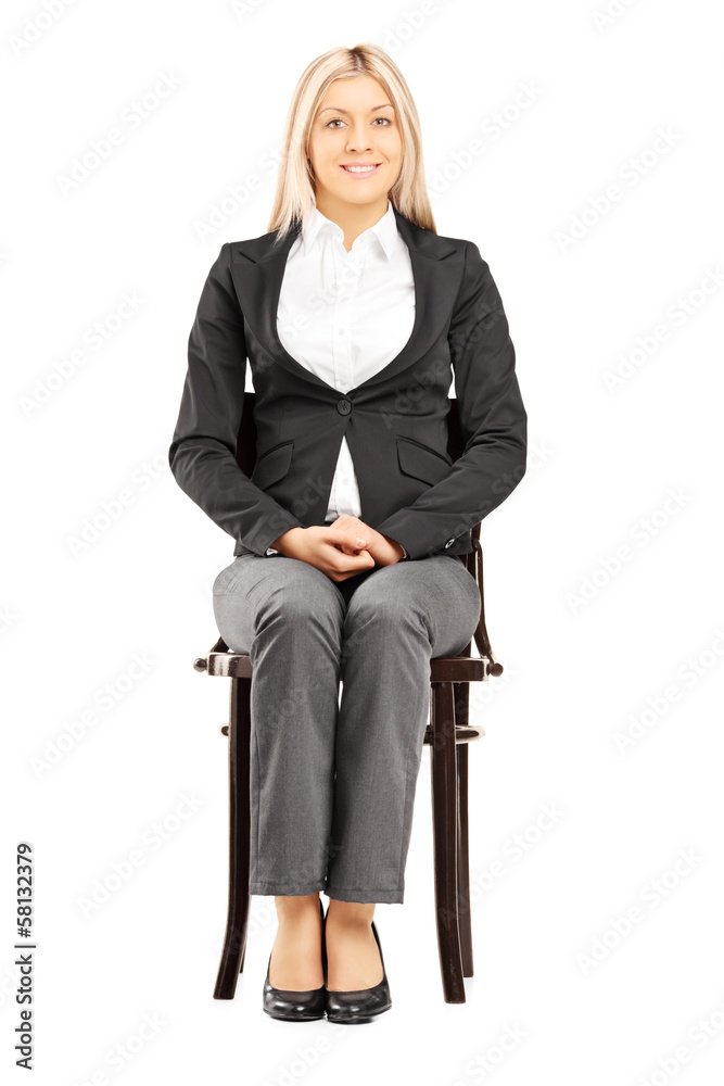 Confident blond businesswoman in suit sitting on a chair Confident blond businesswoman in suit sitting on a chair