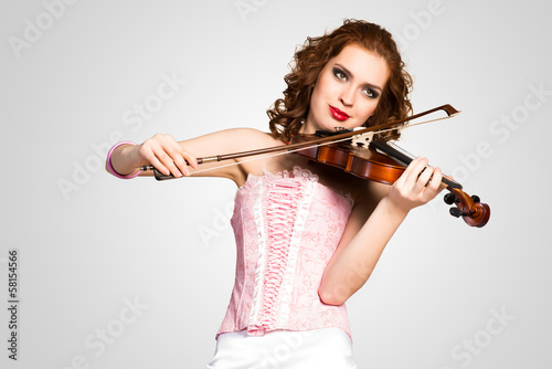 young attractive woman in pink corset on a violin
