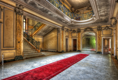 Red carpet in the hallway of an abandoned manor