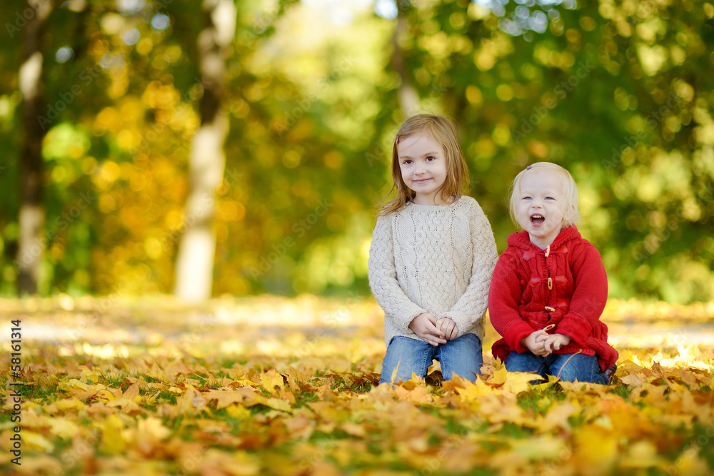 Two little sisters having fun in autumn park Two little sisters having fun in autumn park