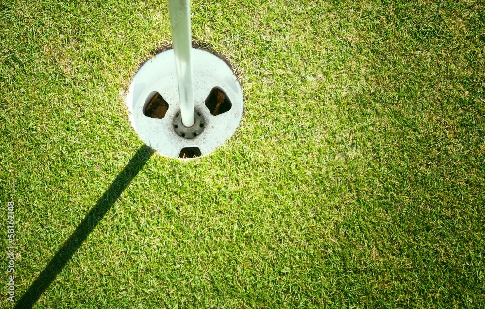 Obraz premium Golf cup on green background with copyspace