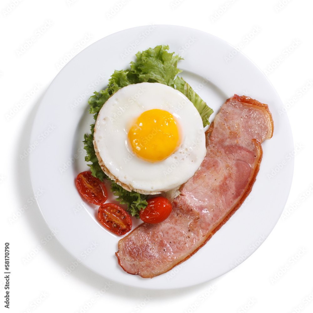 Fried eggs with vegetables and ham isolated.  top view.
