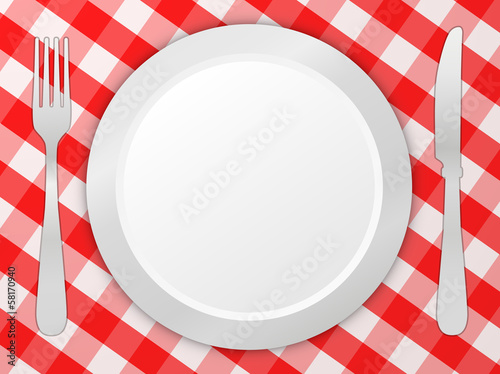 Fork, knife and plate on tablecloth