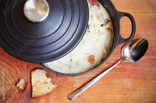 Clam chowder with sausage and potatoes in iron casserole photo