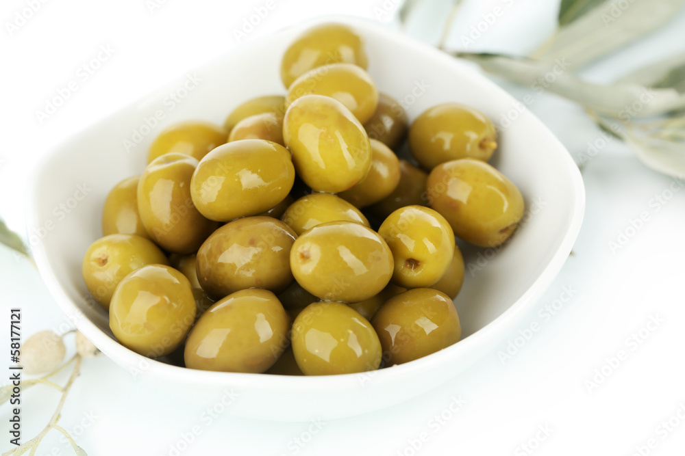Olives in bowl with branch isolated on white Olives in bowl with branch isolated on white