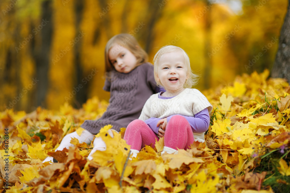 Two little sisters having fun in autumn park Two little sisters having fun in autumn park