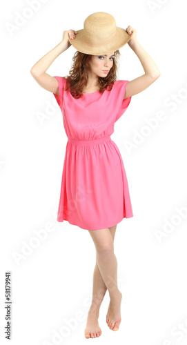 Young woman in pink dress and straw hat posing playfully, summer fashion and vacation lifestyle