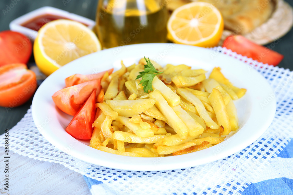 Ruddy fried potatoes on plate on wooden table close-up Ruddy fried potatoes on plate on wooden table close-up