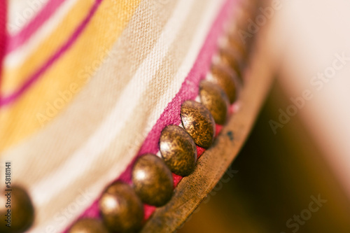 closeup of upholstery tacks on an old traditional wooden chair