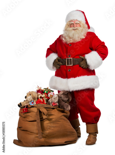 Santa Claus posing near a bag full of gifts
