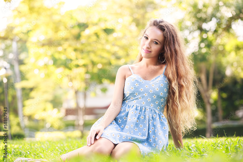 Beautiful young woman sitting at green grass Beautiful young woman sitting at green grass