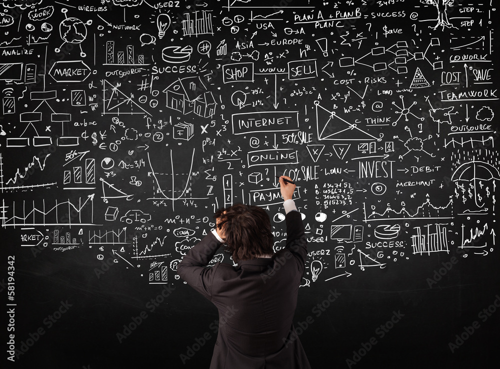 Businessman standing in front of drawn charts on a blackboard Businessman standing in front of drawn charts on a blackboard
