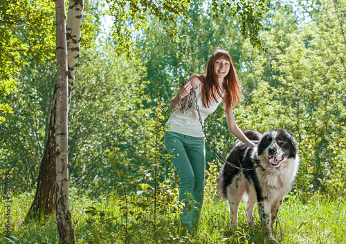 Cute young woman with her Dog in the summer forest