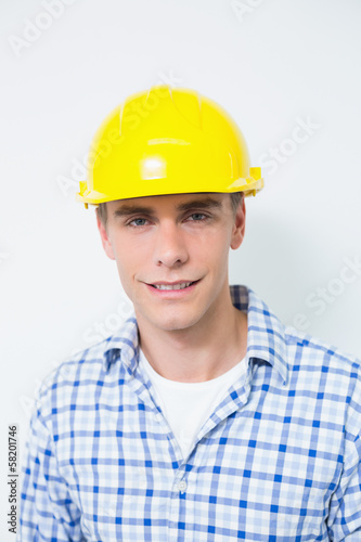Portrait of a smiling handyman wearing a yellow hard hat © lightwavemedia