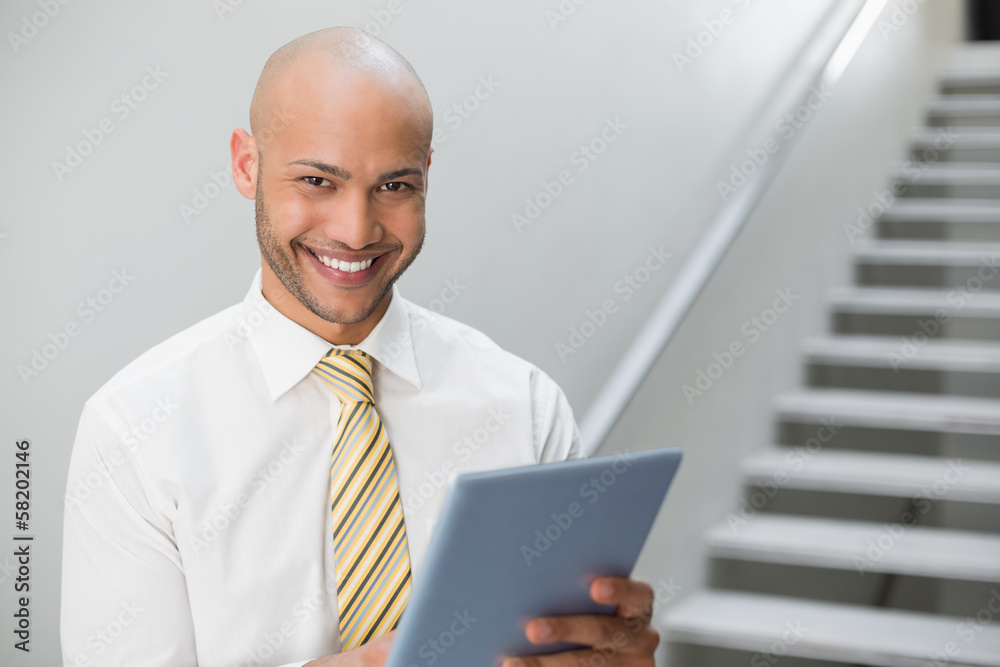 Smiling elegant young businessman using digital tablet Smiling elegant young businessman using digital tablet