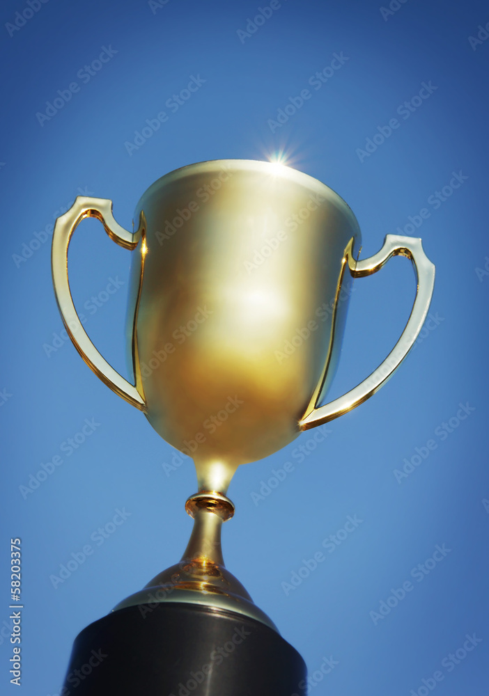 Gold trophy cup against blue Gold trophy cup against blue