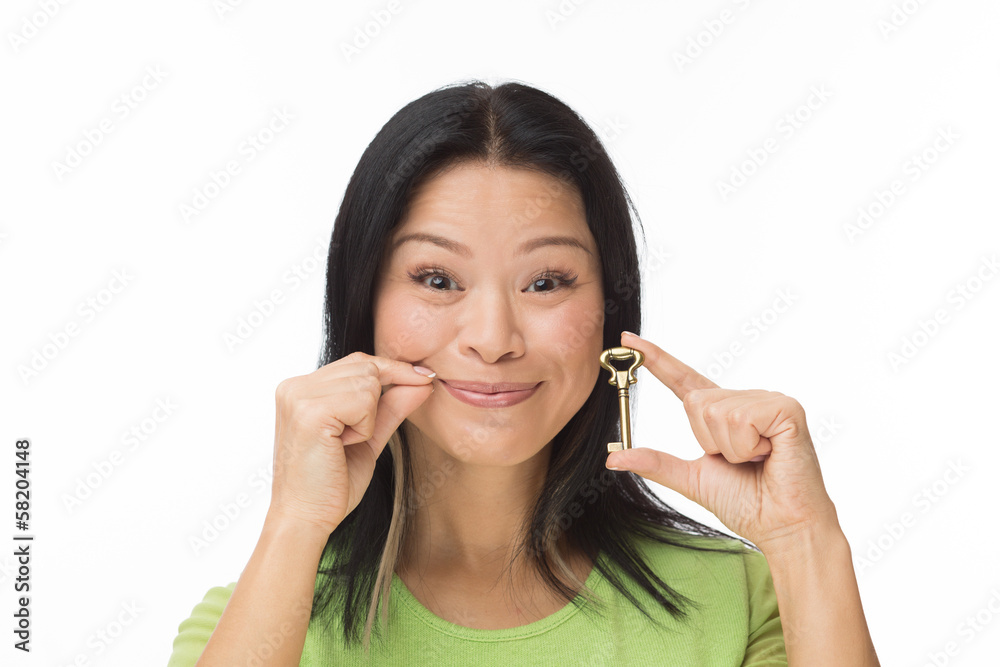 Asian woman keep mouth locked with key isolated on white Asian woman keep mouth locked with key isolated on white