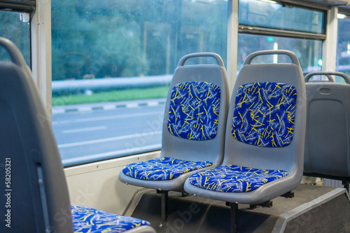 Blue seat places in modern city trolley bus on back side
