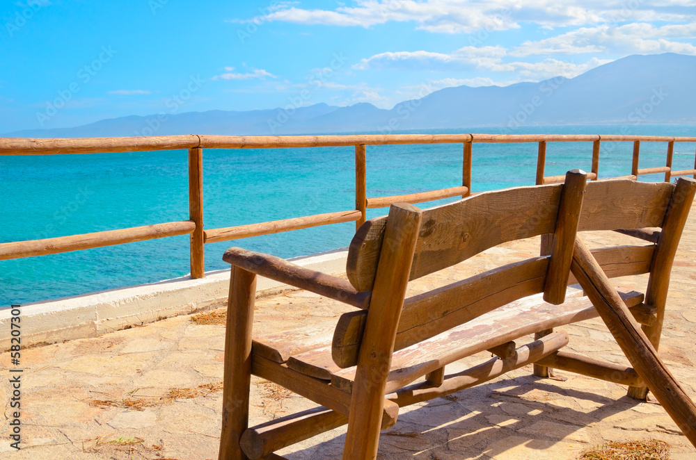 lonely bench on a viewing platform with views of the sea and the lonely bench on a viewing platform with views of the sea and the
