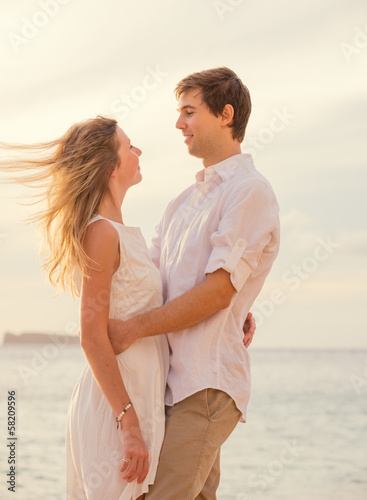 Happy romantic couple on the beach at sunset embracing each othe © EpicStockMedia