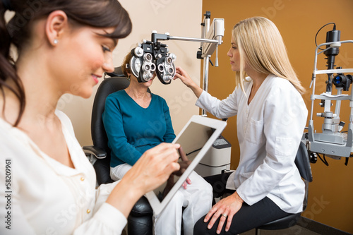 Optometrists Examining Senior Woman In Store photo